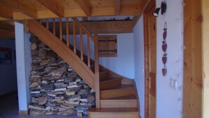 A wooden staircase with a stone wall on one side and a wooden door on the other. - Central Hostel Châtel (Chatel)
