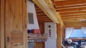 A wooden interior with a stone fireplace, a sofa, and a dining area. - Central Hostel Châtel (Chatel)