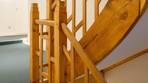 A wooden staircase with a handrail, carpeted steps, and a plain wall in the background. - Goldener Engel Hotel - Restaurant (Heppenheim)