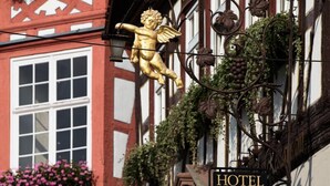 A hotel with a traditional European facade, featuring a sign with a golden cherub and a 'HOTEL' signboard. - Goldener Engel Hotel - Restaurant (Heppenheim)
