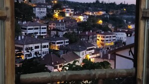 A view through a window of a town at dusk with buildings and street lights visible. - Efe Guest House (Safranbolu)