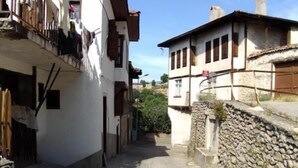 A narrow street with traditional stone walls and buildings with wooden shutters. - Efe Guest House (Safranbolu)