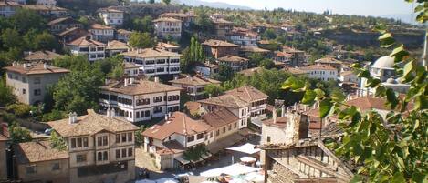 A densely packed town with traditional architecture, including multi-story buildings and a central square with outdoor seating.