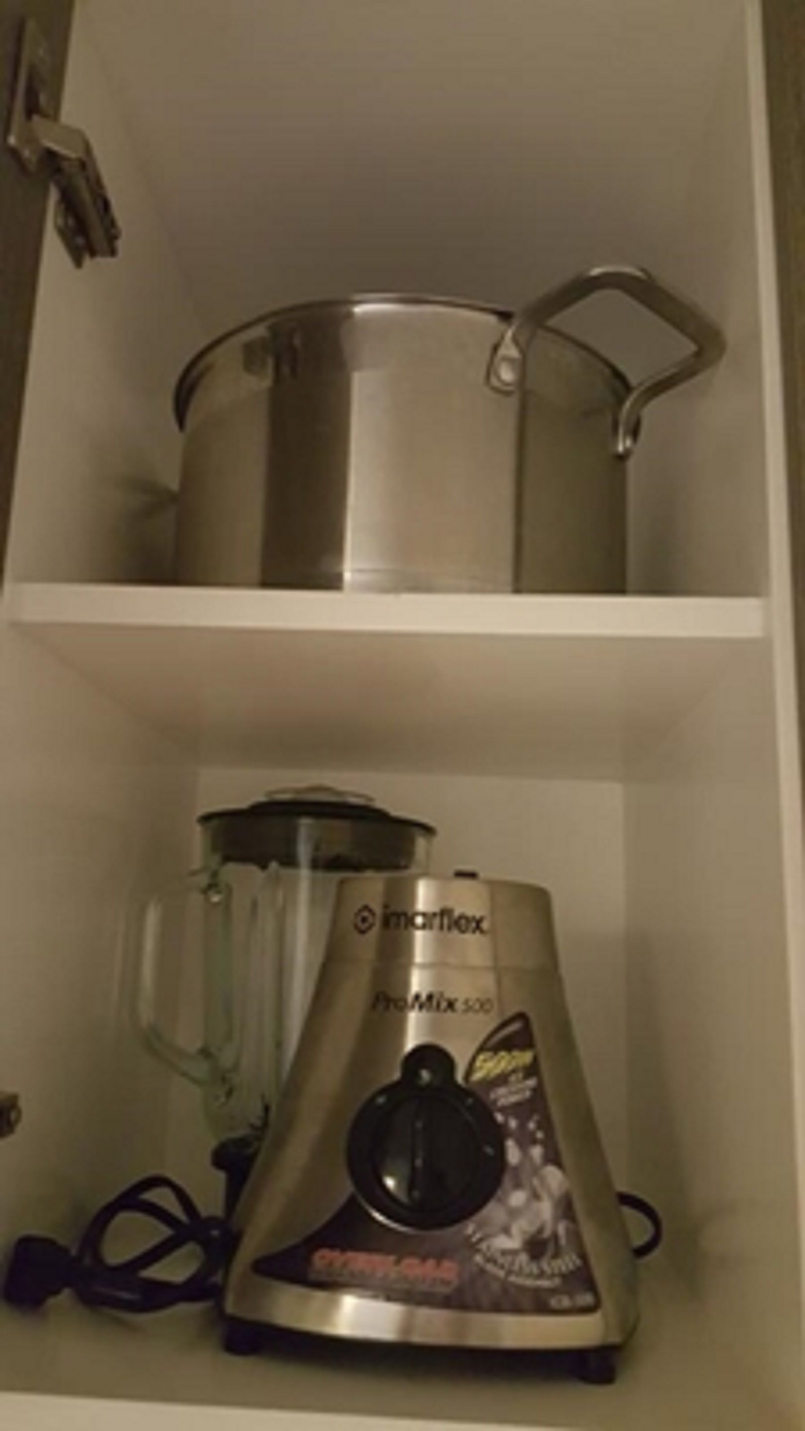 Una cucina con una pentola in acciaio inossidabile sullo scaffale superiore e un frullatore sullo scaffale inferiore.