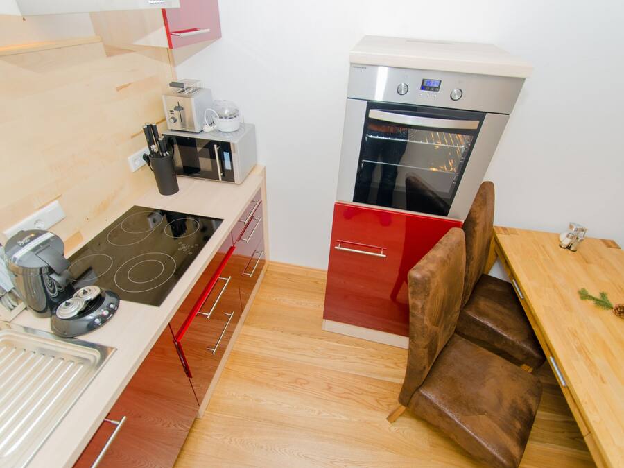 Una cocina compacta con estufa, microondas y horno.