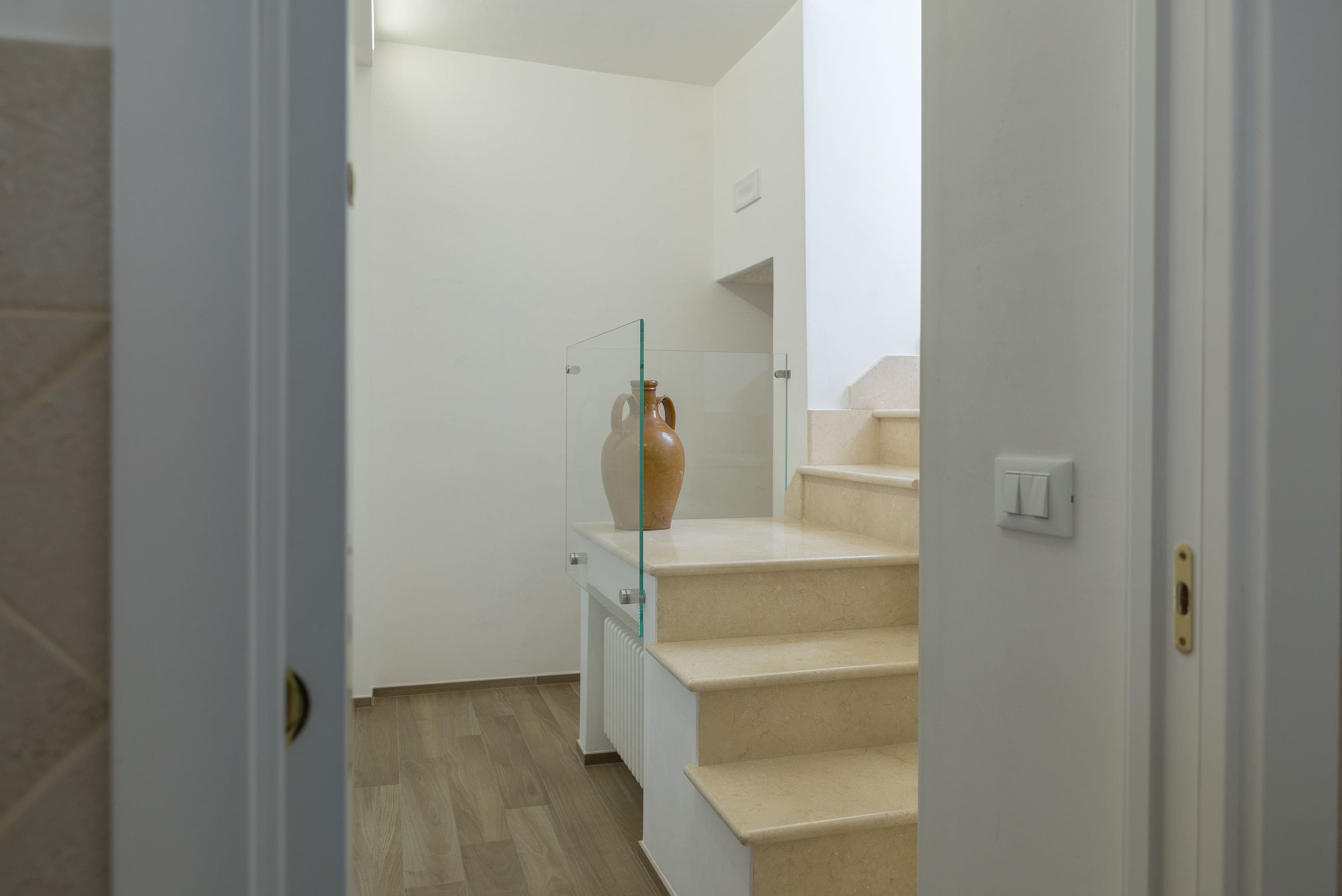 A staircase with a vase on the landing.