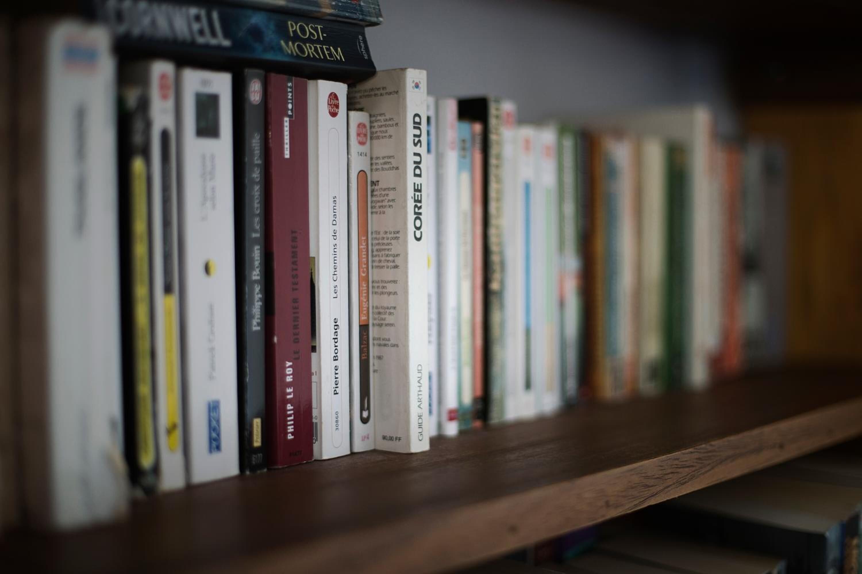 Una estantería con varios libros, incluyendo títulos como 'Post-Mortem' y 'Corée du Sud'.