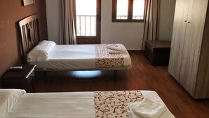 A hotel room with two beds, a desk, a wardrobe, and a window with curtains. - Hostería Verahouse (Jaraíz de la Vera)