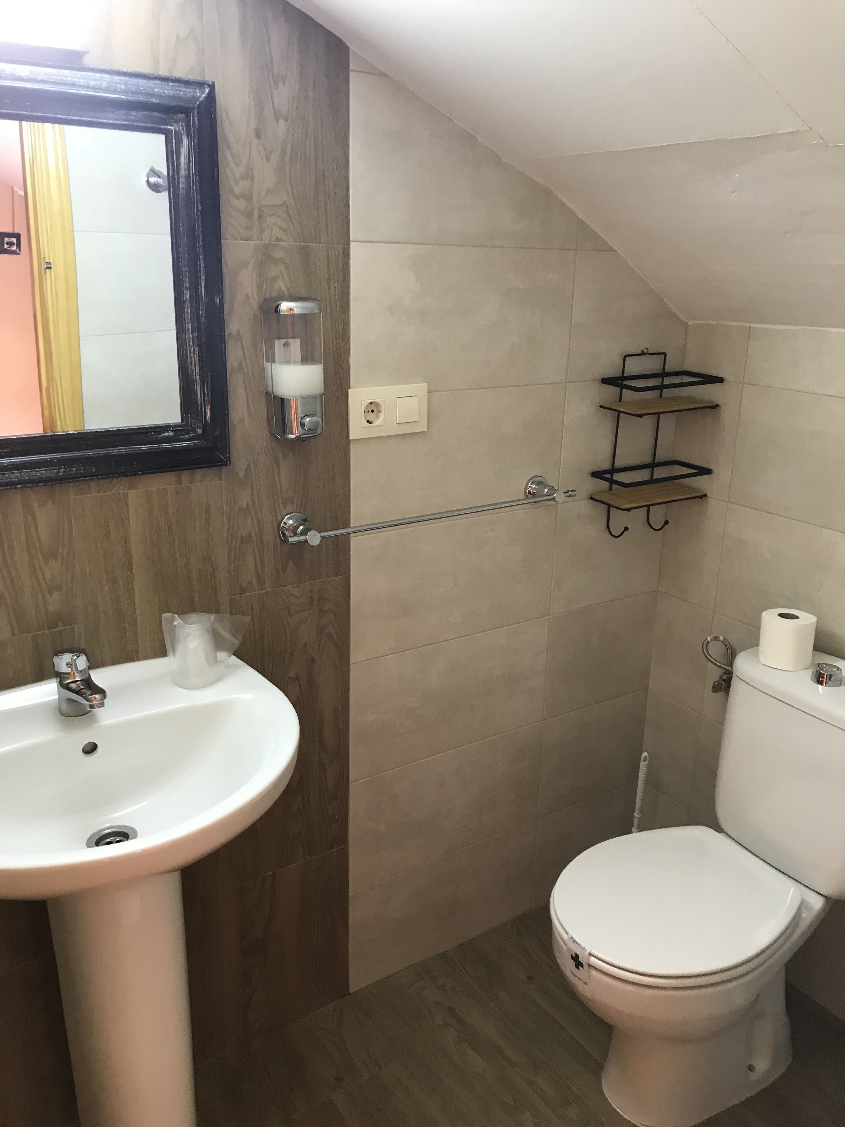 Une salle de bain équipée d’un lavabo, de toilettes et d’un porte-serviettes.