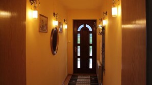 A hallway with wooden walls, a framed picture, and wall-mounted lights. - Grand Panorama (Wisniowa)
