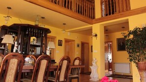 A dining area with wooden furniture, a chandelier, and a staircase. - Grand Panorama (Wisniowa)