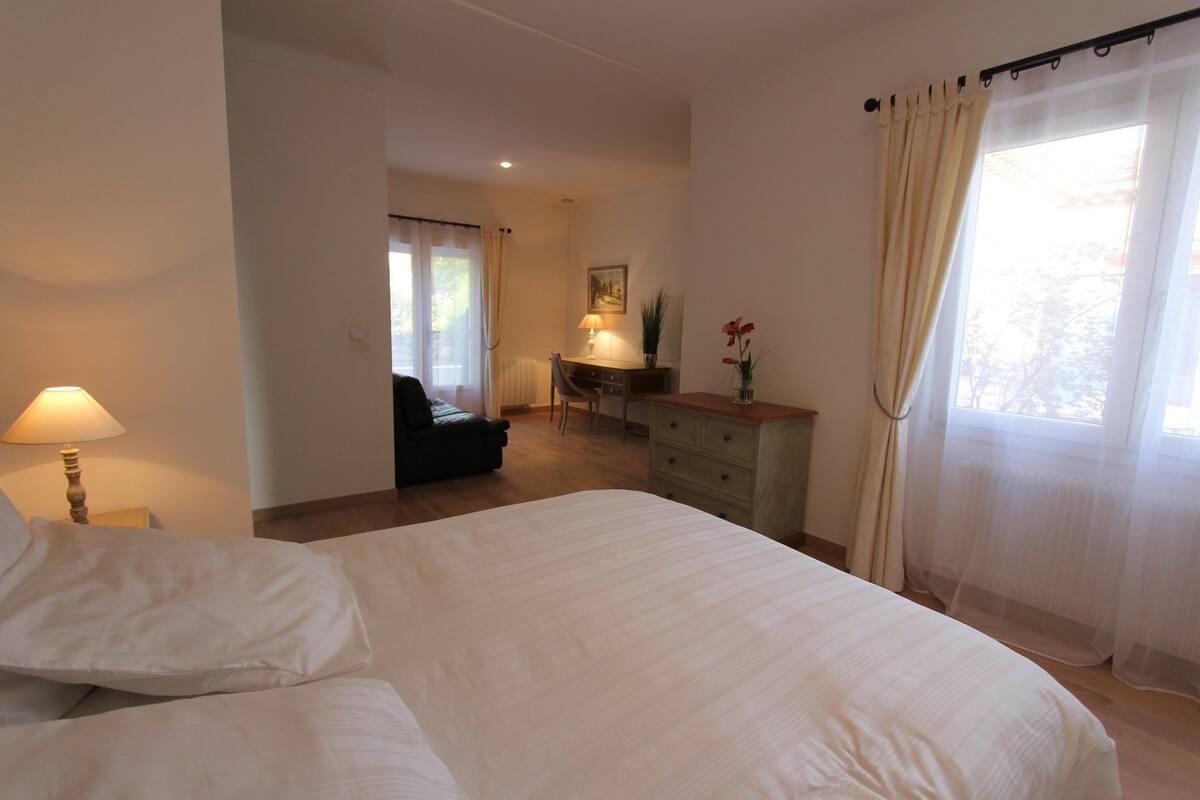 Ein Schlafzimmer mit Bett, Schreibtisch, Stuhl und Lampe.