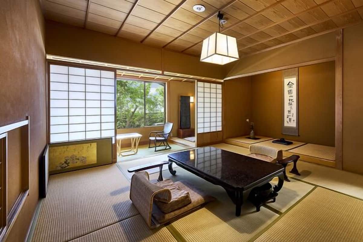 Ein traditioneller japanischer Raum mit Tatami-Bodenbelag, einem niedrigen Tisch und gleitenden Türen.