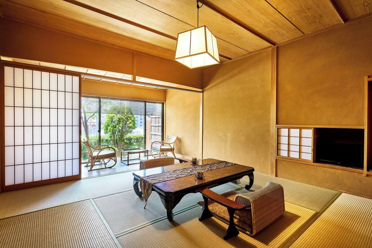 Um quarto japonês tradicional, com piso de tatame, uma mesa baixa e portas deslizantes.