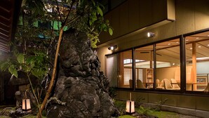 Un edificio moderno con grandes ventanales, un detalle de piedra y un interior bien iluminado.