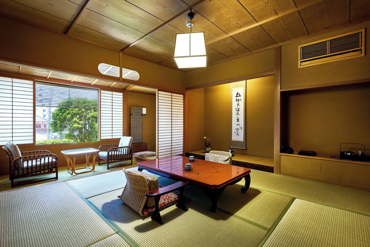 Um quarto japonês tradicional com tatames, uma mesa baixa e dois tatames com almofadas.