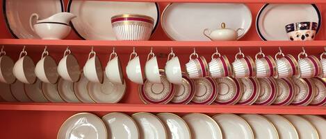 A collection of white and gold dinnerware on shelves.