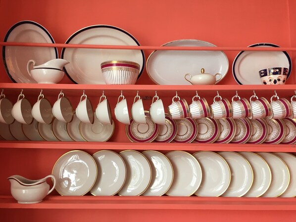 A collection of white and gold dinnerware on shelves. - Square Tree House (Liverpool)