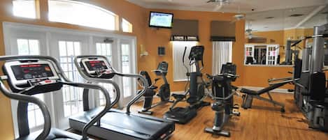 A gym with treadmills, elliptical machines, and weight equipment.