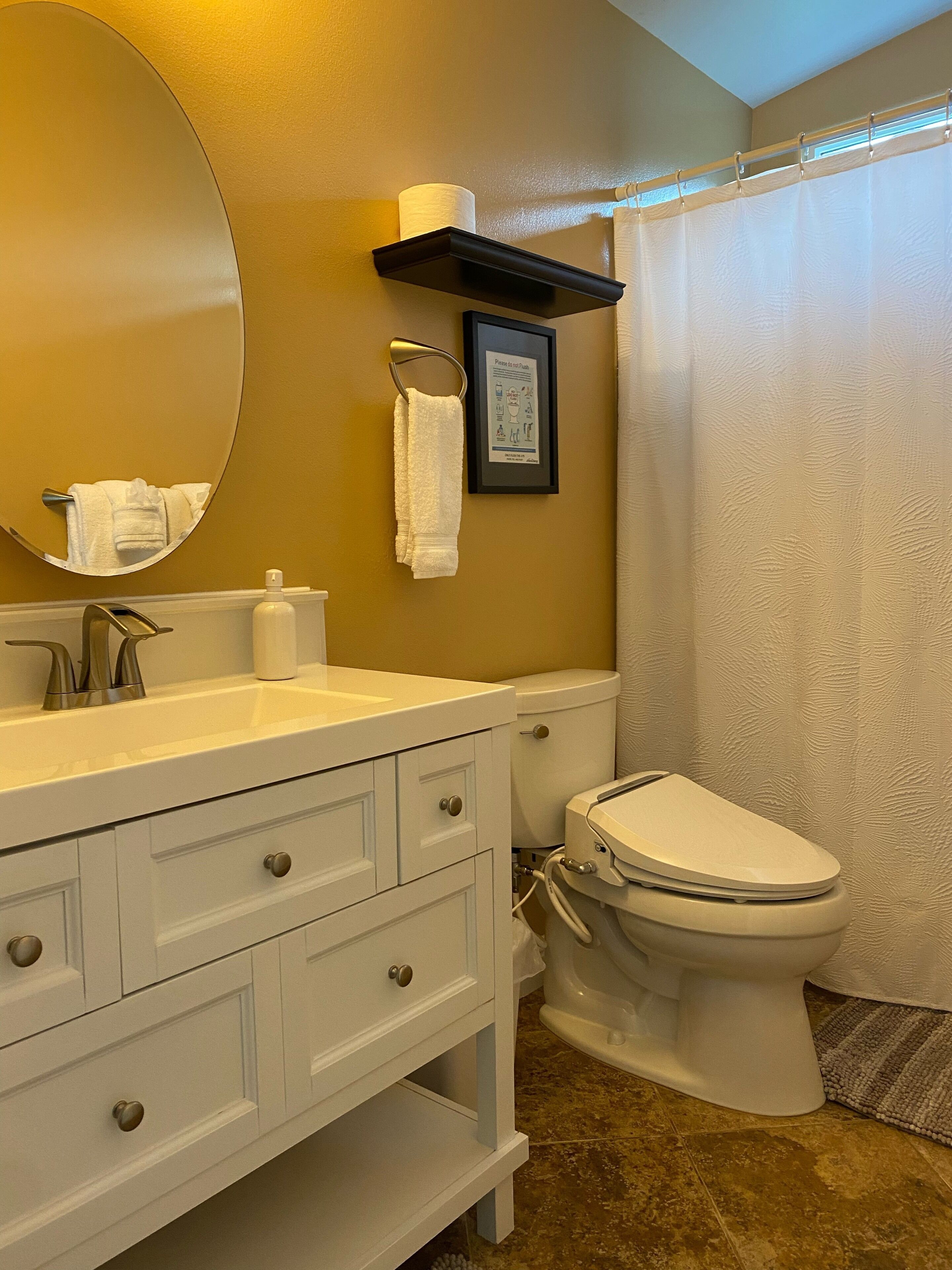 Een badkamer met een witte wastafel, toilet en douchegordijn.