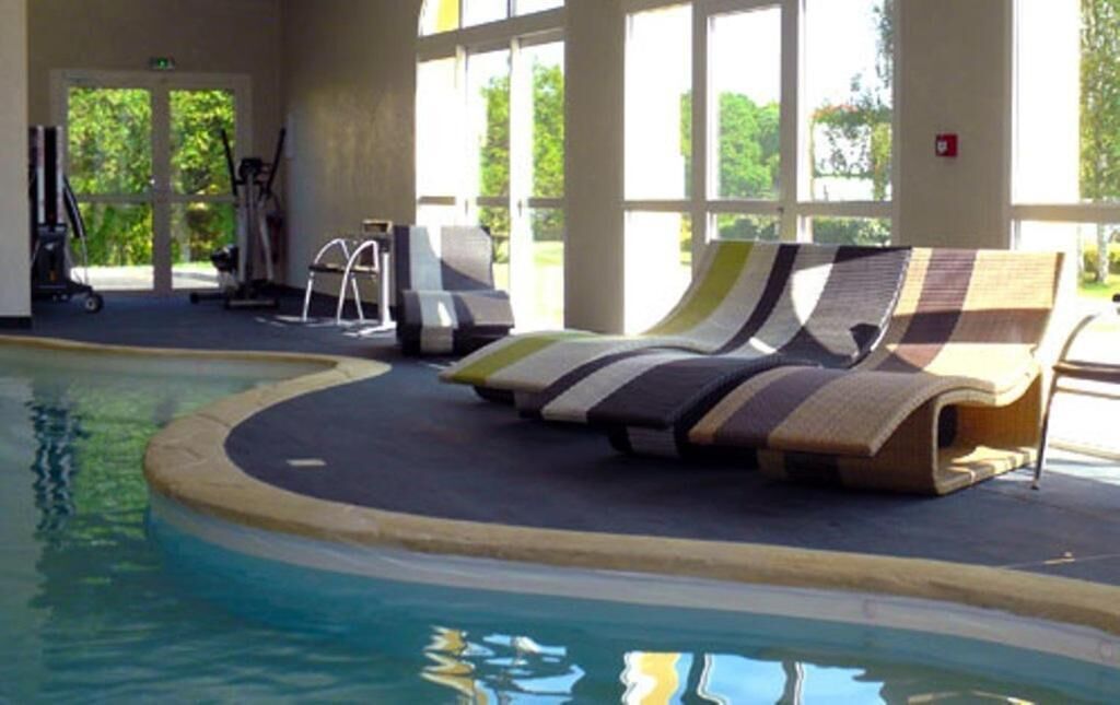 A pool area with lounge chairs and exercise equipment.
