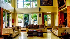 A spacious lobby with a high ceiling, large windows, and a central seating area with sofas and a coffee table. - ISAMILO GRAND HOTEL (Mwanza)