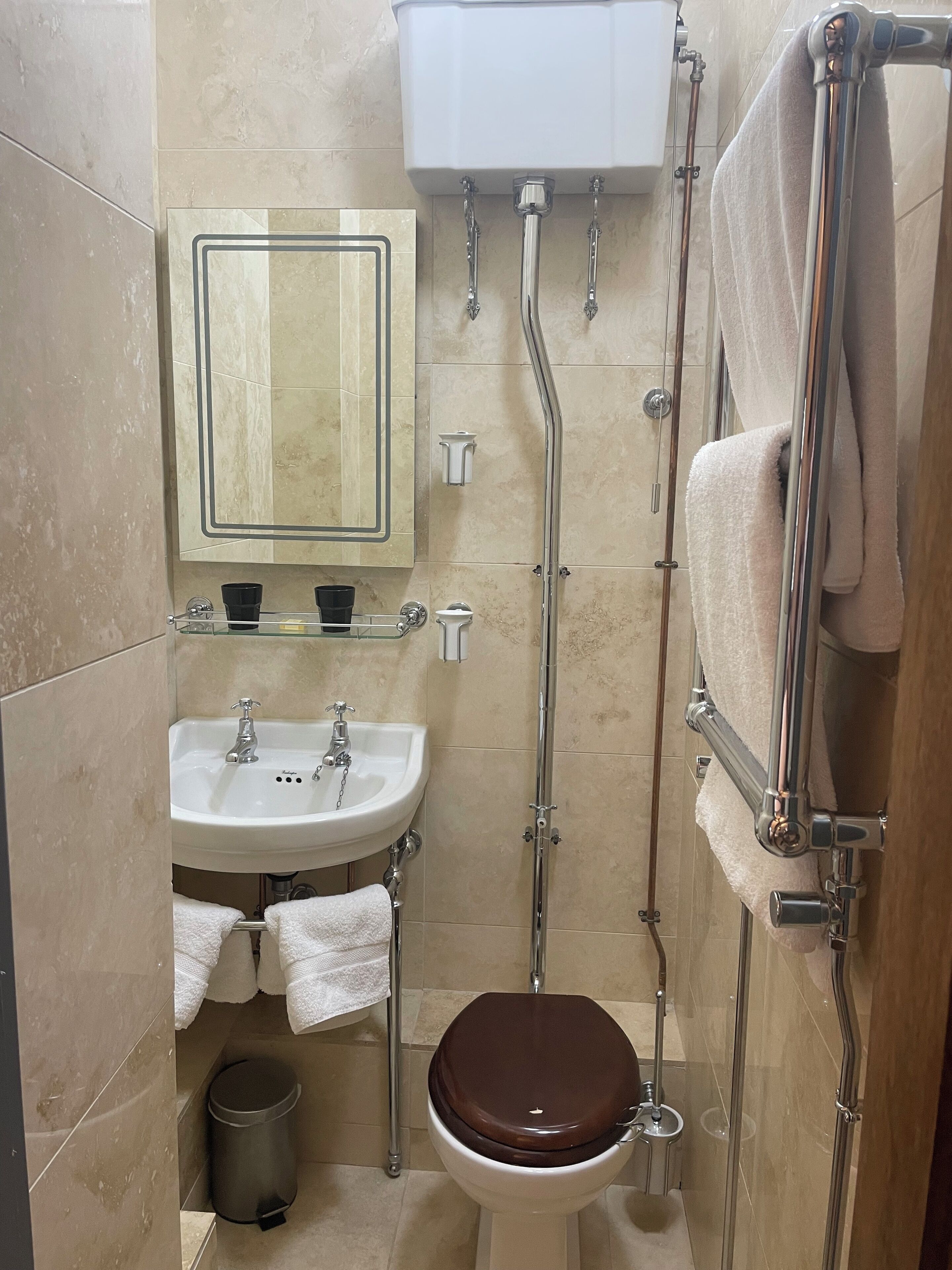 Une petite salle de bain comprenant des toilettes, un lavabo et un miroir.
