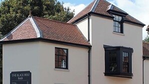 A two-story building with a sign for 'The Black Hole Bar' on the ground floor. - The Black Hole (Winchester)