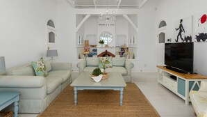 Un salon comprenant un canapé, une table basse, un meuble pour la télévision et des objets de décoration.