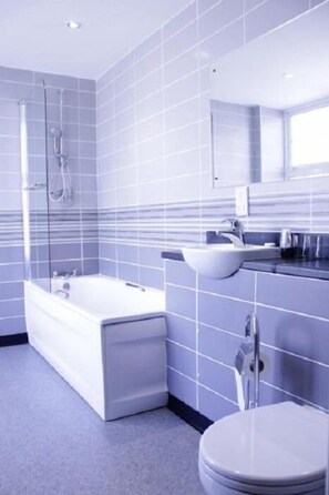 Et moderne badeværelse med badekar, håndvask og toilet.