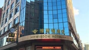 A modern hotel with a curved glass facade and a sign reading "Wisdom Hotel". - Wisdom Hotel (Maoming)