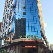 A modern hotel with a curved glass facade and a sign reading "Wisdom Hotel".