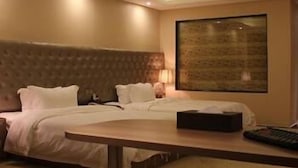 A hotel room with a large bed, a smaller bed, a desk, and a large window. - Wisdom Hotel (Maoming)