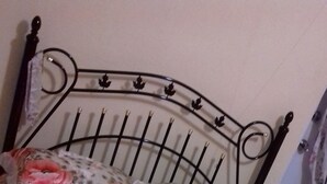 Un letto con struttura in metallo e copripiumino a motivi floreali.