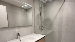 A modern bathroom with a white sink, wooden vanity, and a glass-enclosed shower area. - Cozy 2-room south in Tignes with wifi, near slopes (Tignes)