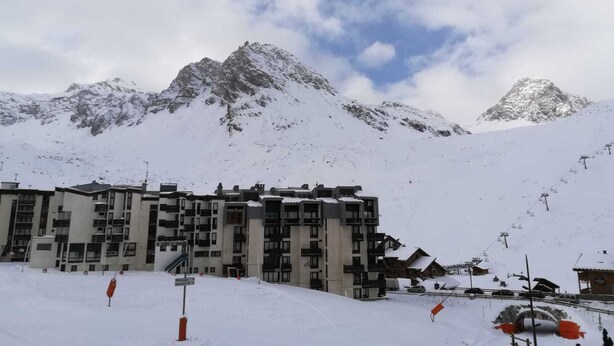 A snow-covered mountain with a ski resort, including a multi-story building with balconies and a ski lift in the background. - Ski-in studio, mountain view, perfect for 4 (Tignes)