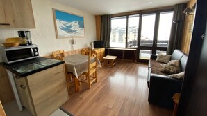 A compact living space with a kitchenette, a dining area, and a seating area with a view of the city. - Ski-in studio, mountain view, perfect for 4 (Tignes)