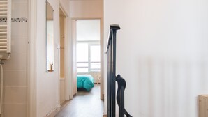 A hallway with a wooden floor, a bathroom with a shower, and a bedroom with a bed and window. - Renovated 3-room duplex at the foot of the slopes with WiFi in Tignes (Tignes)