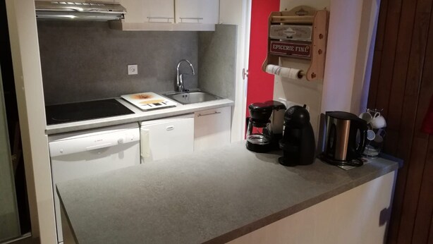 A compact kitchen with white cabinets, a sink, a stove, and a coffee maker. - Charming 2-room in Tignes, 100m from slopes, South/West balcony (Tignes)