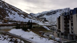 A mountainous landscape with a road leading to a building with multiple floors and balconies. - Charming 2-room in Tignes, 100m from slopes, South/West balcony (Tignes)