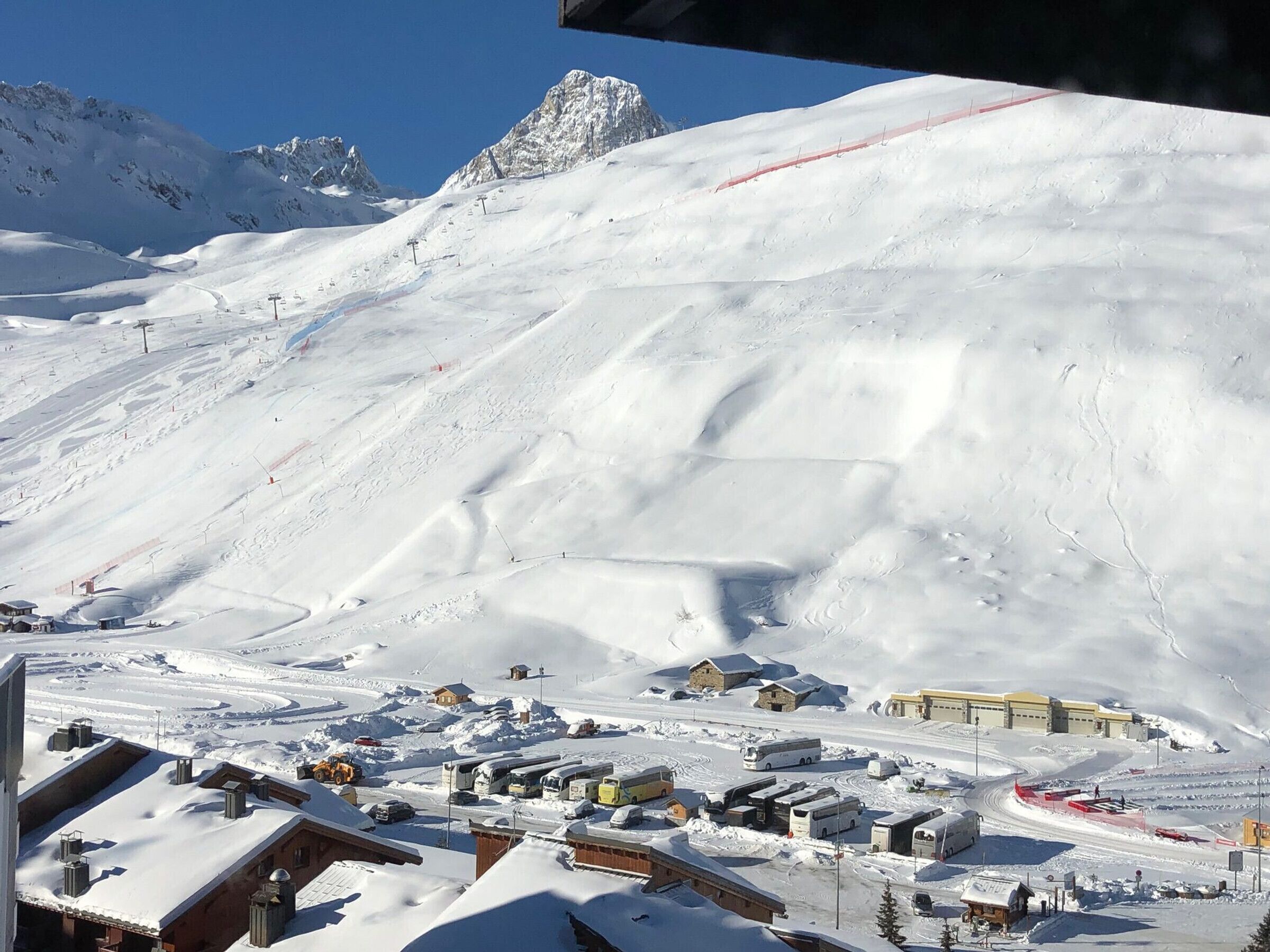 Ein mit Schnee bedeckter Berg mit einem Skigebiet, einschließlich Gebäude, Straßen und Seilbahnen.