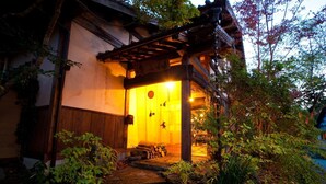 A traditional Japanese building with a wooden exterior and a stone pathway leading to the entrance. - Yufuin TAGASODE (Yufu)