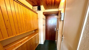 A narrow hallway with wooden paneling on one side and a door at the end.