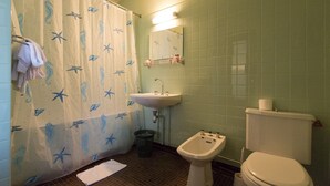 A bathroom with a shower curtain featuring sea creatures, a sink, a bidet, and a toilet. - Hotel Espellet (Larceveau-Arros-Cibits)