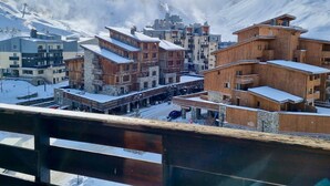 A snow-covered mountain town with wooden buildings and a ski lift in the background. - Studio with balcony and wifi 500m from slopes (Tignes)