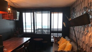 Un interior acogedor con una mesa de comedor de madera, un sofá con cojines y una pared con diseño.