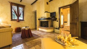Una sala de estar acogedora con chimenea, televisor y comedor con mesa lista para una comida.