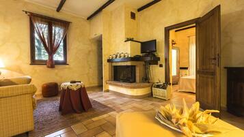 Una sala de estar acogedora con chimenea, televisor y comedor con mesa lista para una comida.