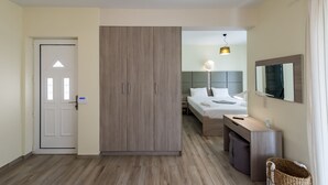 A modern hotel room with a wardrobe, a bed, a desk, and a bathroom. - Sun, Sand & Seclusion - Artemis with Private Pool (Pylos-Nestoras)