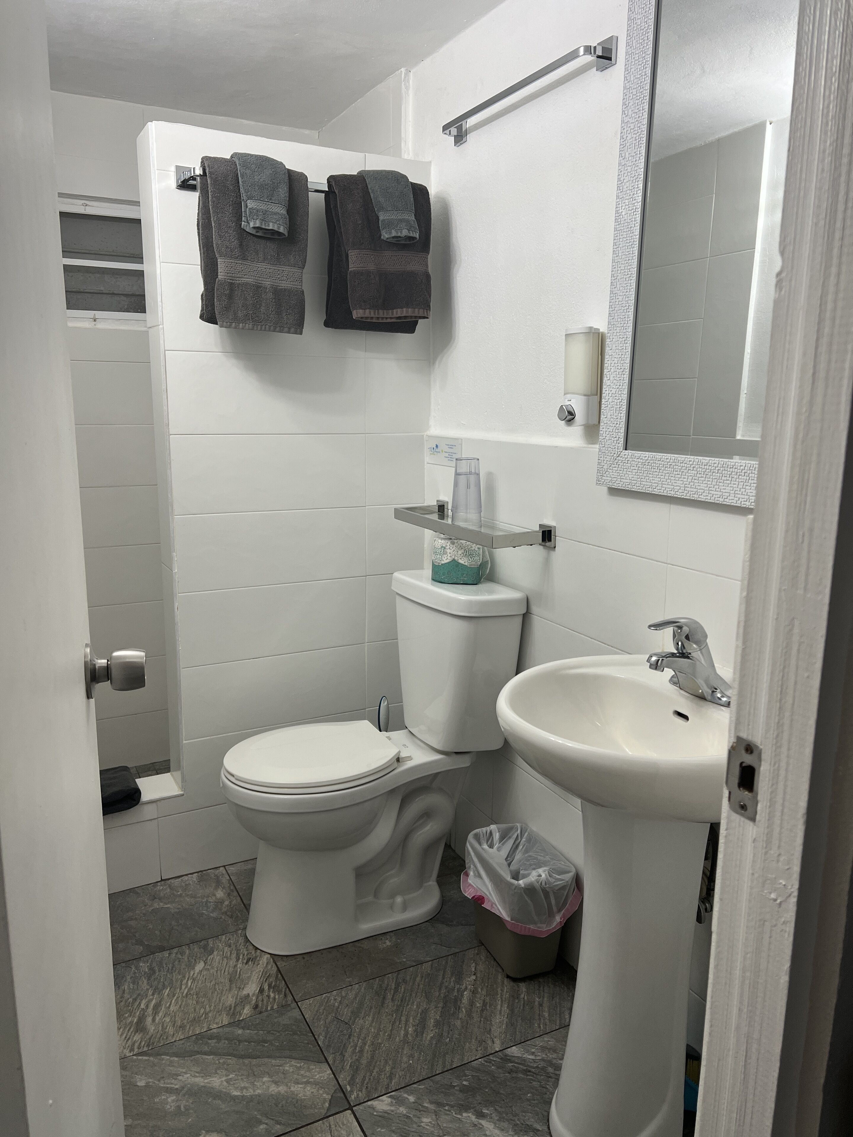 A bathroom with a toilet, sink, and towel rack.